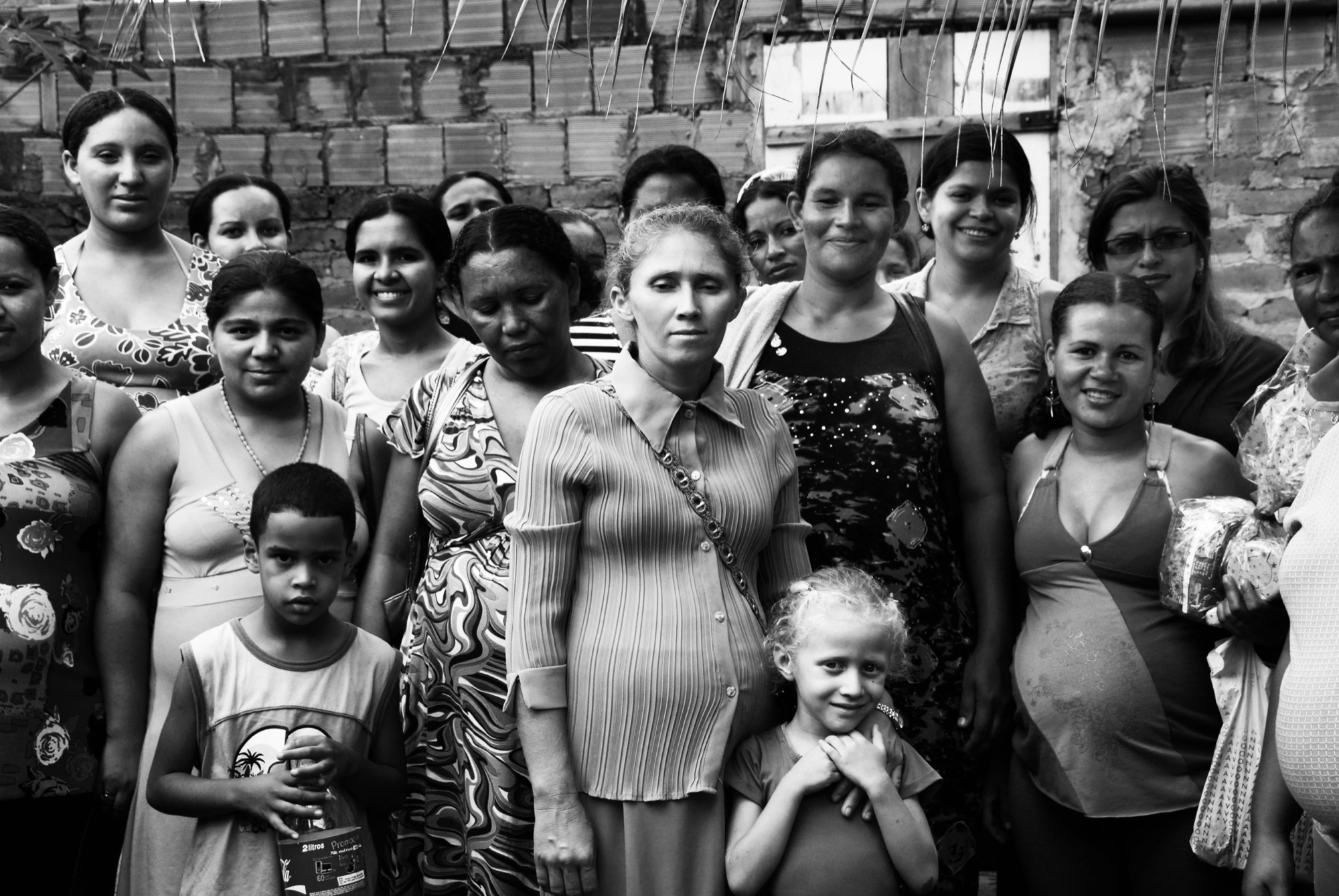 Grupo de mulheres, muitas grávidas, e crianças reunidas em atividade comunitária de saúde